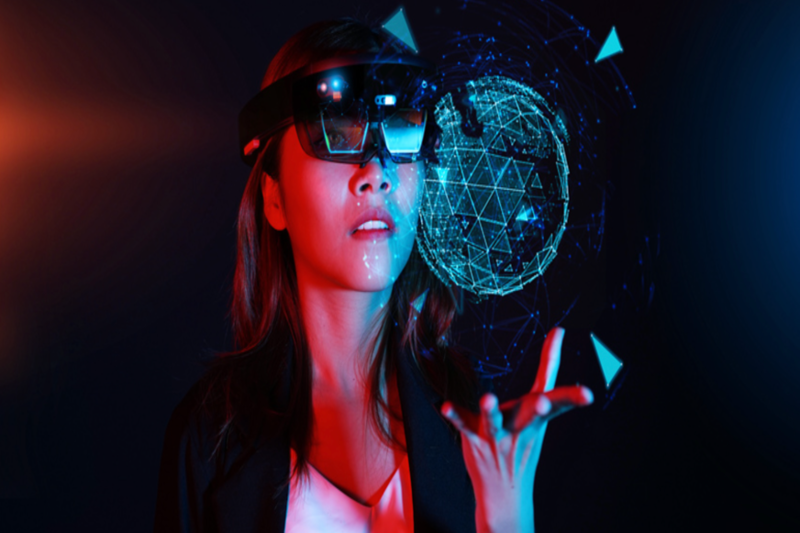 Man sieht eine Frau mit Smart Glasses, die virtuelle Elemente projizieren.